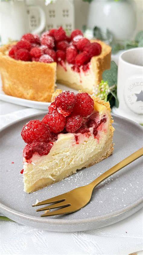 Ricotta-Kuchen mit Himbeeren auf einem Teller, leicht bestäubt mit Puderzucker
