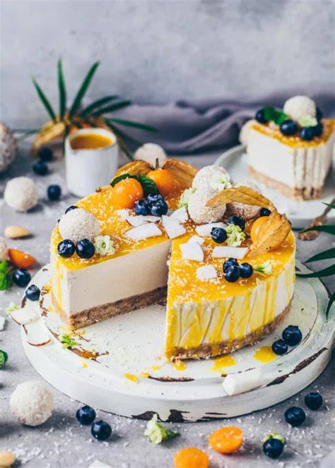 Roher veganer Kokos-Cheesecake mit Mangosauce und Raffaello-Dekor