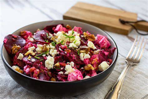 Rote Bete Salat mit Feta, Walnüssen und Dressing angerichtet auf einem Teller