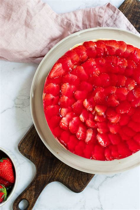 Roter Tortenguss als Abschlussschicht auf dem Erdbeerkuchen