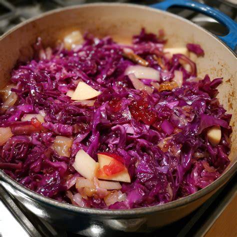 Rotkohl in einem Topf mit Gewürzsäckchen und Apfelstücken