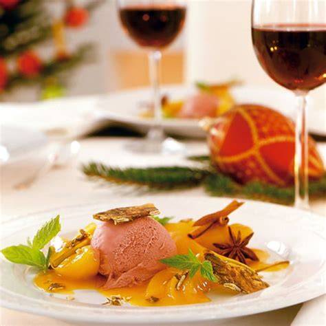 Rotweineis anrichten: Schüssel mit dunkelroter Eiscreme, Glas Rotwein, Vanilleschote, orange Zesten