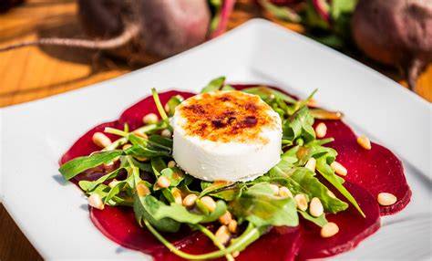 Rucola mit Ziegenkäse und Honig auf Teller, angerichtet