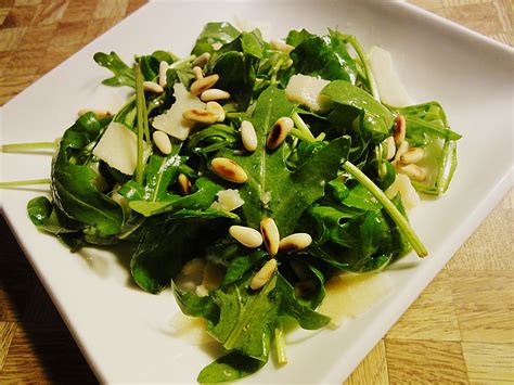 Rucola-Salat mit Pinienkernen und Honig-Dressing, angerichtet auf Teller