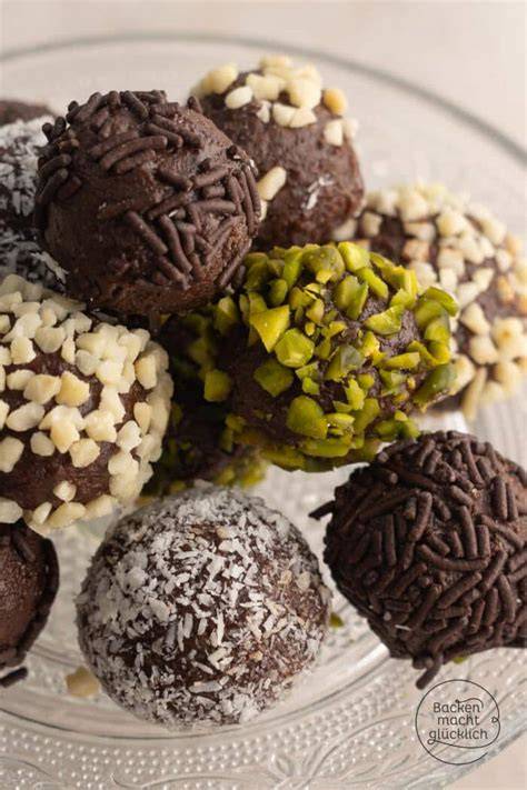 Rumkugeln auf Teller, daneben Puderzucker und Schokostreusel