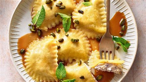 Runde süße Maultaschen (Cjalçons) mit Pistazien und Sahne serviert