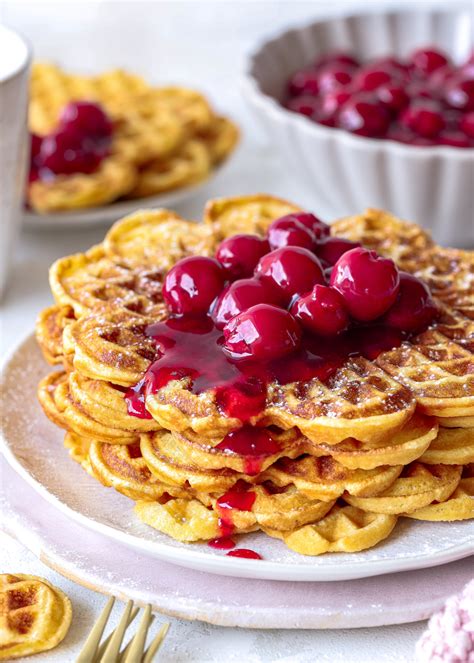 Süße Waffelpommes mit Puderzucker und Kirschen