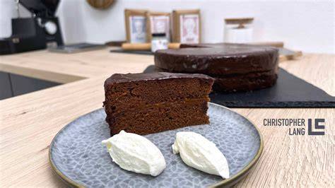 Sachertorte auf Servierplatte mit Glasur und Schlagobers