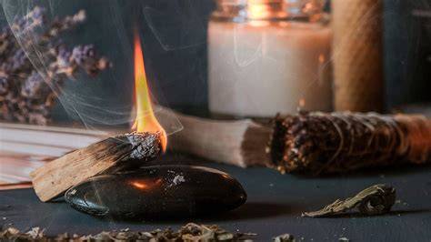 Sacred Space: Kerze, Tasse Kakao, Palo Santo und Journal auf einem kleinen Altar