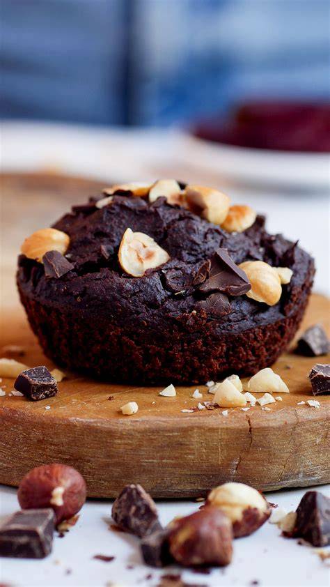 Saftige Rote Bete Muffins auf einem Teller, im Hintergrund frische Rote Bete und Datteln