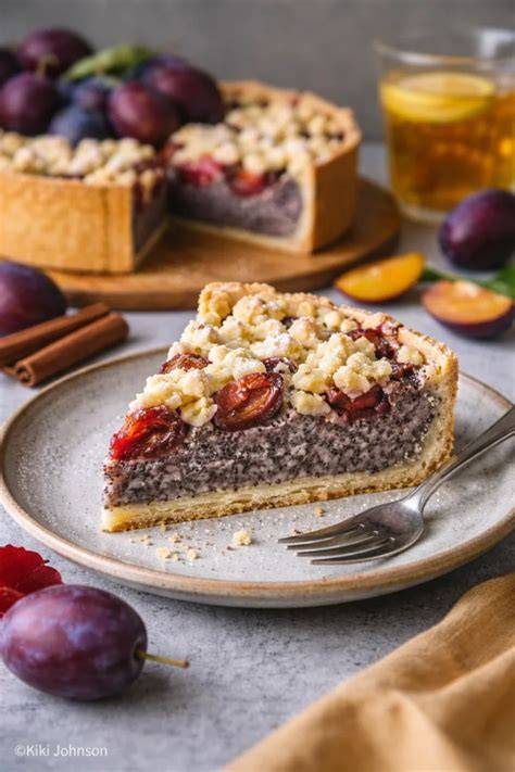 Saftiger Trockenpflaumen-Kuchen mit Streuseln und Zwetschgen auf einem weißen Teller