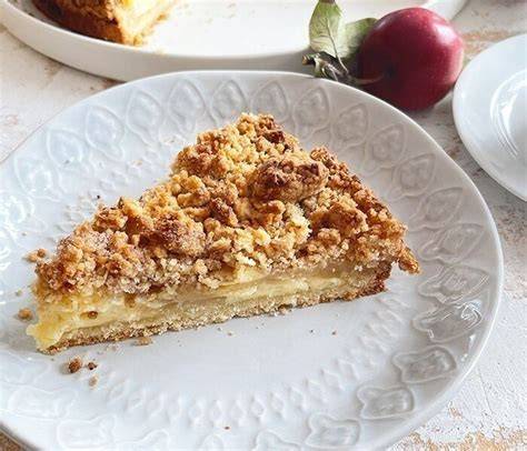 Saftiger Vanille-Apfelkuchen mit Vanillecreme und Apfelstücken auf Holzbrett