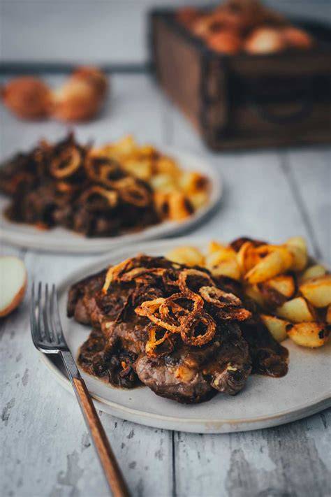 Saftiger Zwiebelrostbraten mit Bratkartoffeln und Röstzwiebeln, rustikal angerichtet