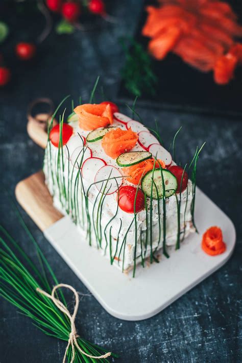 Sandwichtorte dekoriert mit Räucherlachs, Gurke, Radieschen und Schnittlauch