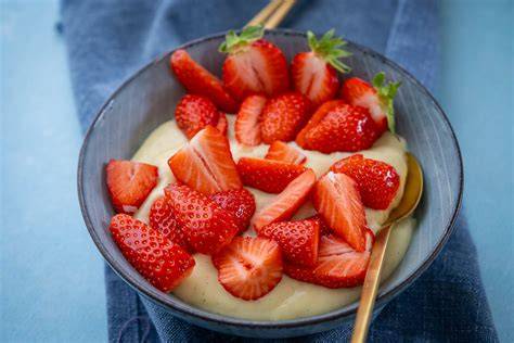 Schälchen mit Vanillepudding und frischen Erdbeeren, dekorativ geschichtet