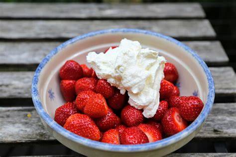 Schälchen mit gezuckerten Erdbeeren und Sahne