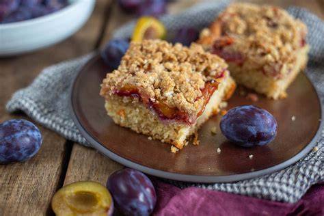 Schön angerichteter glutenfreier Blechkuchen mit Sahne und Zwetschgen