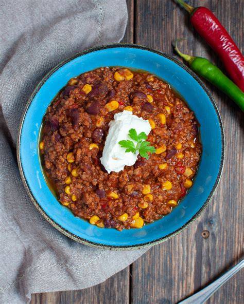 Schüssel Chili con Carne mit frischer Petersilie und einem Klecks Schmand