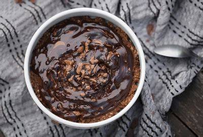 Schüssel heißes Schoko-Porridge mit Löffel und Topping