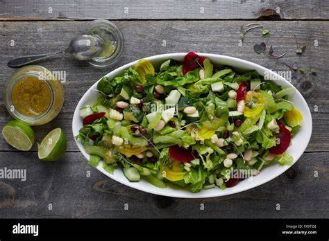Schüssel mit Balsamico-Vinaigrette neben Salat