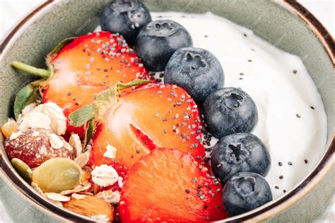 Schüssel mit Beeren-Müsli, Joghurt und frischen Beeren als Frühstück