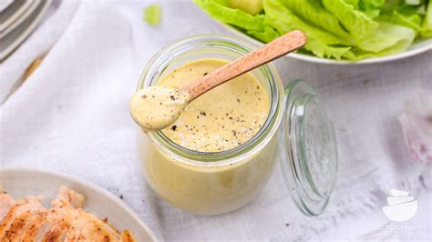 Schüssel mit Honig-Senf-Dressing und Kräutern