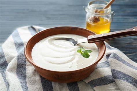 Schüssel mit Magerquark und Honig, Löffel