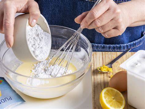 Schüssel mit Quarkcreme, daneben Vanillepuddingpulver, Zitronenabrieb und Orangenzeste