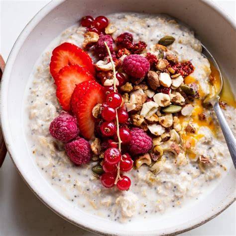 Schüssel mit Schoko-Haferbrei, garniert mit Beeren und Nüssen