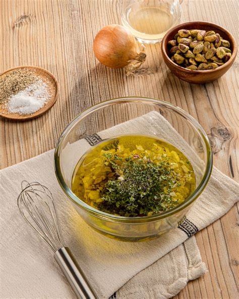 Schüssel mit Vinaigrette, Schneebesen und Zutaten