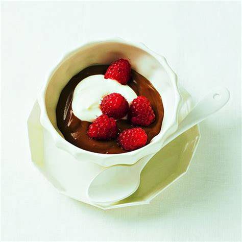 Schüssel mit cremigem veganem Schokopudding, garniert mit Himbeeren und Kokosjoghurt