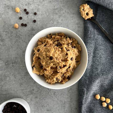 Schüssel mit essbarem Cookie Dough und Löffel, daneben Schokotropfen und Vanilleschote