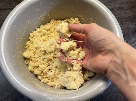 Schüssel mit frischen Streuseln, Hand knetet Teig