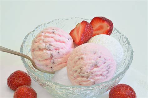 Schüssel mit leuchtend rosa Erdbeereis und frischen Erdbeeren