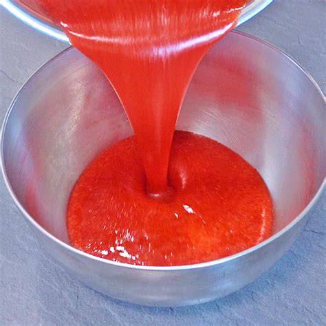 Schüssel mit leuchtend rotem Erdbeerpüree und Dose Kondensmilch