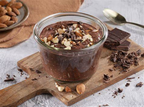 Schüssel mit schokoladigen Overnight Oats, garniert mit Mandeln und Schokolade