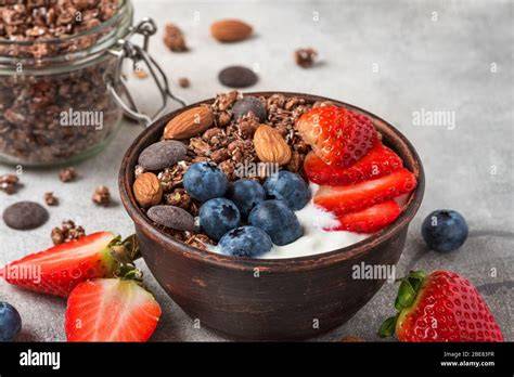 Schüssel mit selbstgemachtem zuckerfreiem Granola, Nüssen und Beeren