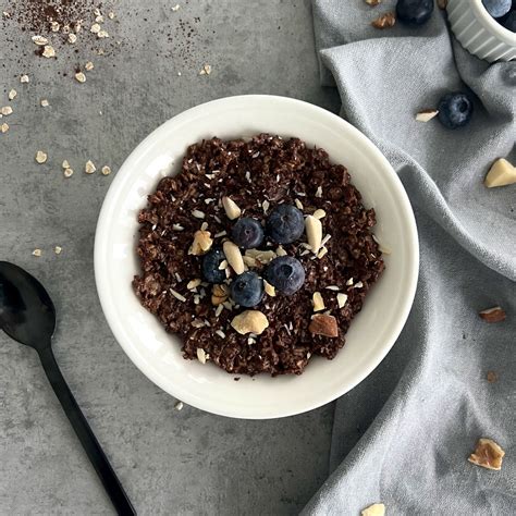 Schüssel mit warmem Schoko-Porridge, garniert mit Nüssen und Rosinen