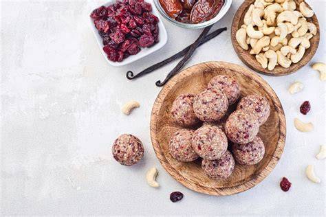 Schüssel mit zerkleinerten Cashews und Datteln neben geformten Cookies