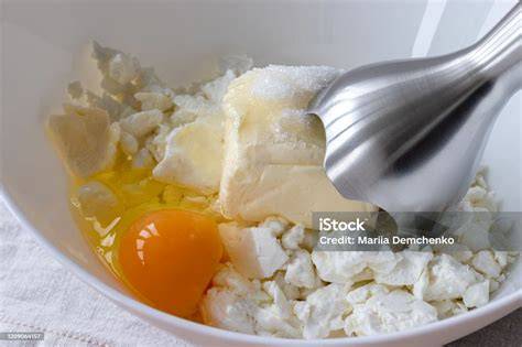 Schüssel mit zimmerwarmer Butter, Handmixer und gesiebtem Puderzucker