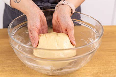 Schüsseln mit Dampfl und aufgegangenem Hefeteig