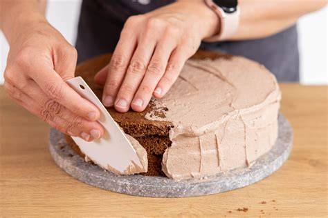 Schachbrett-Torte beim Einstreichen mit Buttercreme