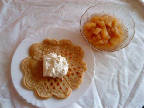 Schale mit Apfelkompott und Waffeln mit Puderzucker