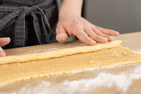 Schema: Teig und Marzipan übereinanderlegen, aufrollen und schneiden