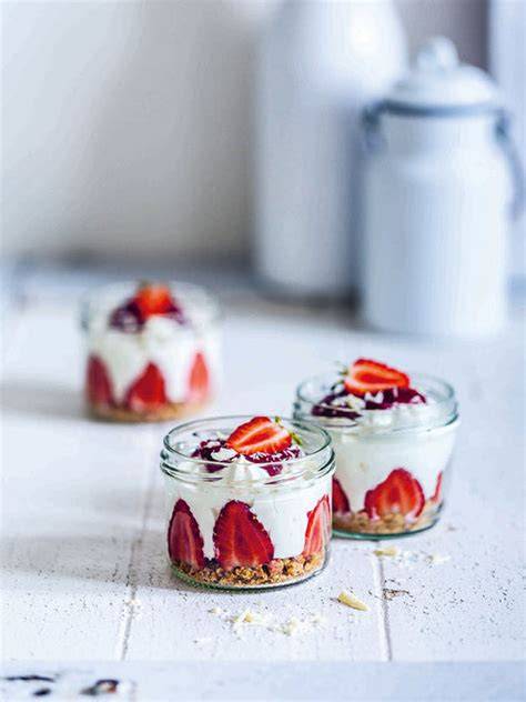 Schichtaufbau eines Erdbeer-Joghurt-Desserts im Glas (Keksboden, Joghurt, Erdbeeren, Topping)
