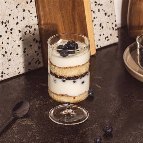 Schichtdessert mit Heidelbeeren, Keksen und Creme als Schema