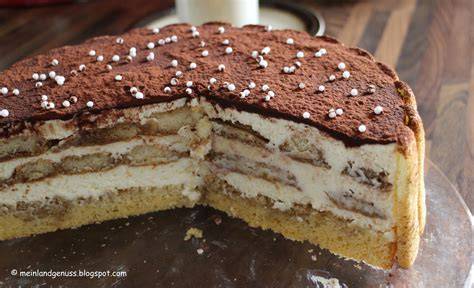 Schichten der Tiramisu Torte: Biskuit tränken, Creme auftragen, weitere Biskuitschicht