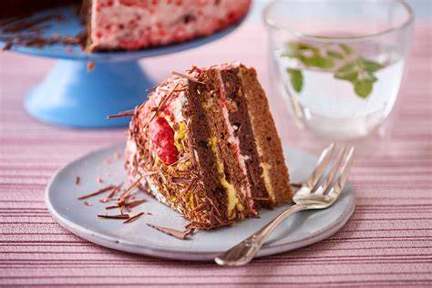 Schichttorte mit Milchreis, Kirschkompott und Schokoraspeln im Anschnitt
