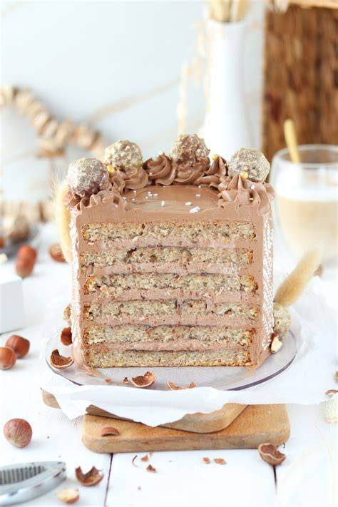 Schichtweise Aufbau der Ferrero Rocher Torte mit Creme und Rocher-Stücken