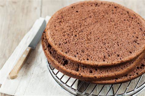Schichtweise geschnittener Schokoladenbiskuit für die Yogurette Torte